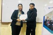 A student receives a certificate of completion for successfully participating in the Professional Development Program.