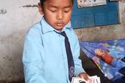A nursery student engages in an interactive classroom activity learning to identify various vegetables.