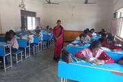 Students engaged in a classroom session under the supervision of a teacher.
