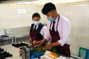 A hospitality student perfecting food and beverage service techniques during a hands-on practical session.