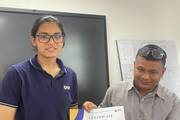 A student receiving a certificate of participation upon the successful completion of a training workshop.