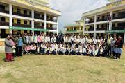 Group photo of students and staff within the premises of Mahendra Secondary School.