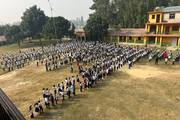 Students participating in the daily morning assembly and prayer session in the playground.