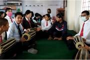 A practical music session in which students learn to play the Madal, a traditional instrument.
