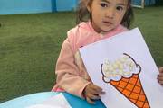 A Montessori student showcasing a creative hands-on art project during a classroom activity.