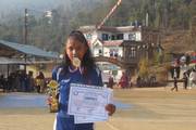 A student proudly displays her trophy and certificate for achieving excellence during the events.