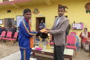 A student receiving a cash prize during the prize distribution ceremony.
