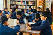 Students engaging in reading and independent study within the school library.