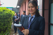 A student in school uniform within the school premises of Dibya Deep Jyoti English Secondary School.