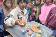 A student demonstrates a solar system model during the science exhibition organized at Shree Secondary School.