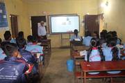 A teacher conducting a classroom session using an interactive smart board.