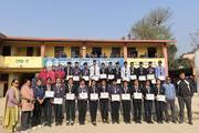 Students of Amarjyoti Secondary School receiving medals and certificates.