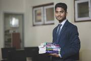 A student holding a collection of science textbooks at Dibya Deep Jyoti English Secondary School.