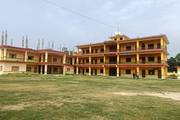 The academic building of Shree Jaldhar Kamaldev Model School surrounded by a spacious open playground.